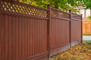 Wooden fence around home with leaves on the ground